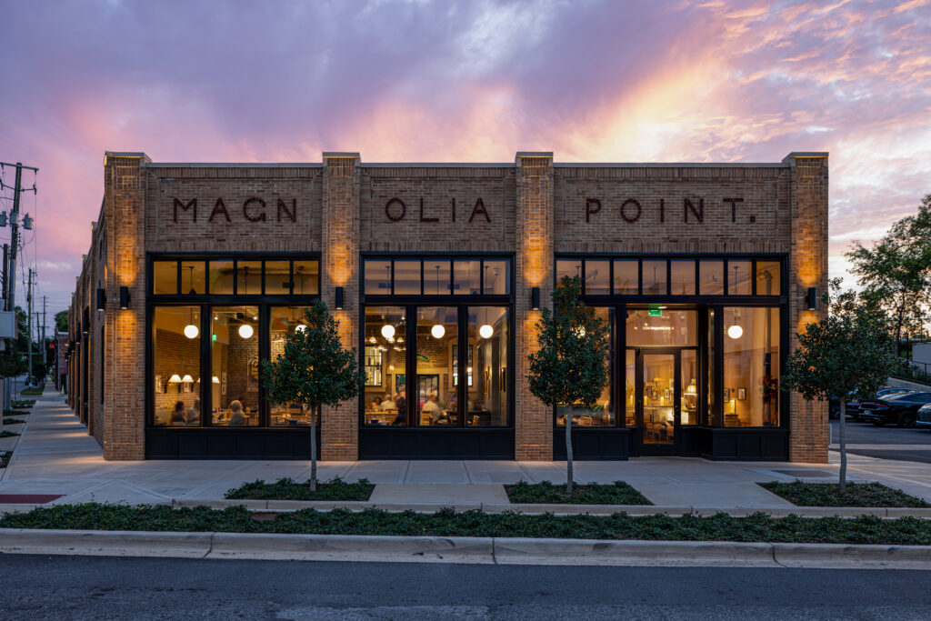 Magnolia Point, a rehabilitated historic commercial building with restored brick signage, lit at dusk